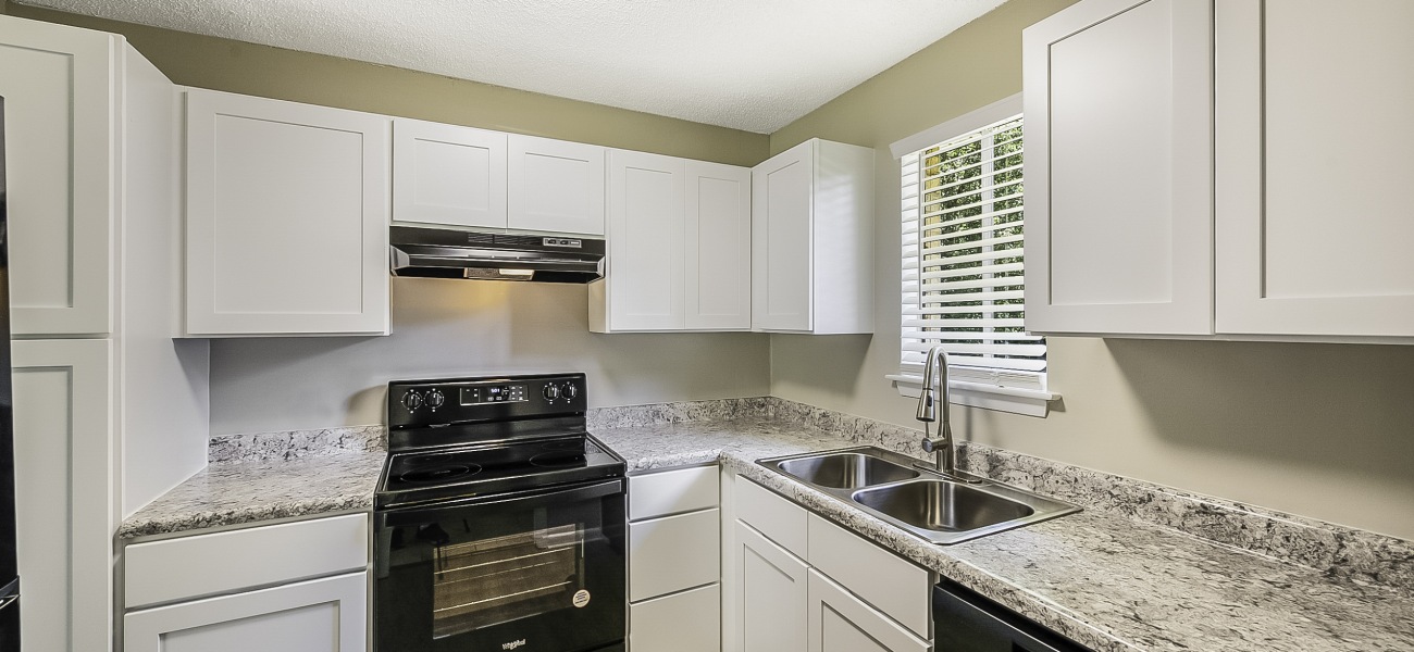 spacious and well lit kitchen with granite counter tops and stainless steel appliances 